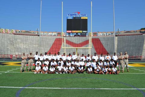 Group of students posing for photo on a football field