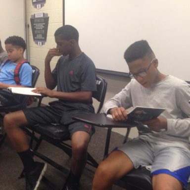 Boys reading a book in the class