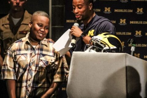 small boy and anchor standing on the stage