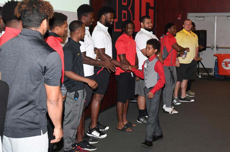 Small boy shaking hands with people