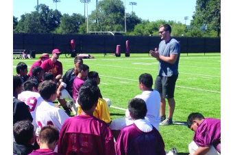 Students sitting on the ground with the coach