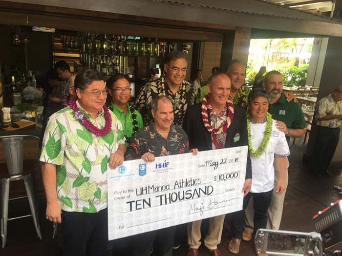 Group of men holding a cheque of amount 10000 and standing for a photograph