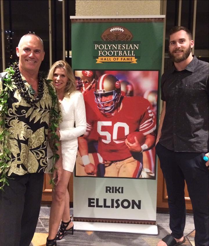 2 men and 1 women standing in front of the banner