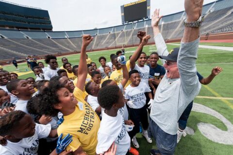 Children's enjoying with coach in the stadium