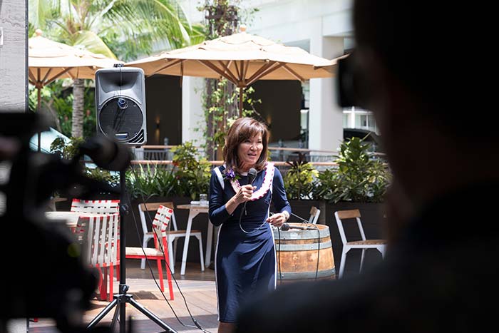 Lady in a blue dress talking in an event