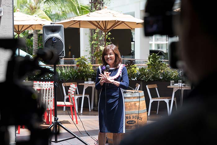 Lady in a blue dress talking in an event