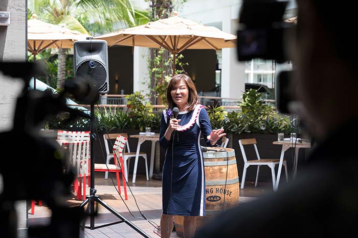 Lady in a blue dress talking in an event