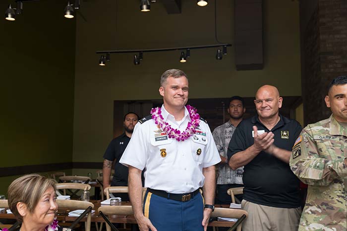 Man in the white uniform smiling