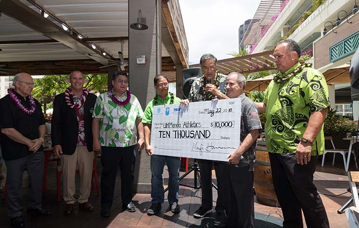 Group of men holding a cheque of amount 10000