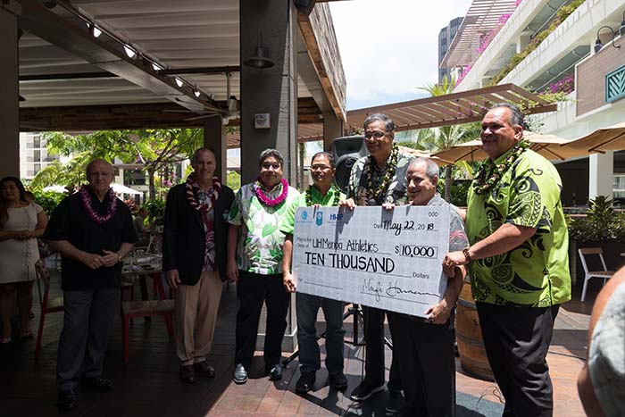 Group of men holding a cheque of amount 10000