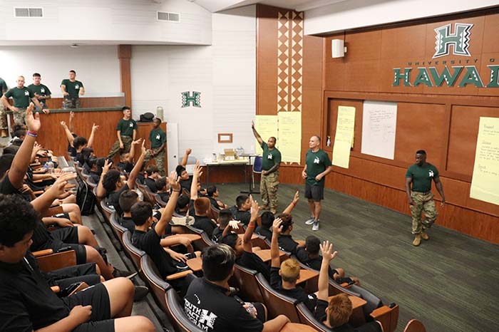 Boys raising their hands in the classroom