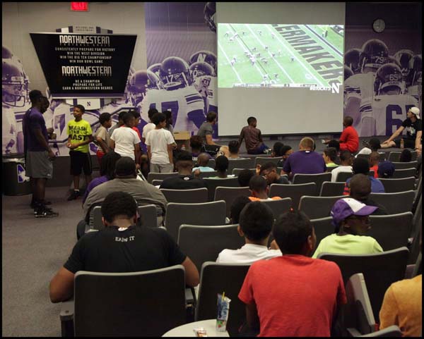 Students and adults watching the game on screen