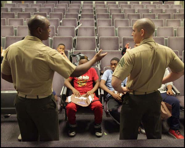 Two officers explaining something to students in class