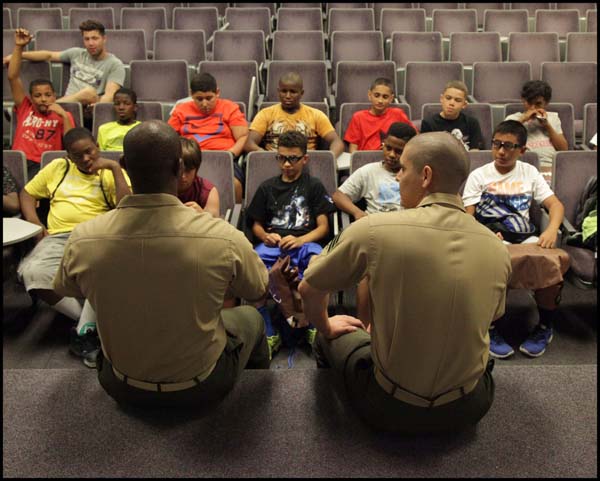 Police officers explaining to students in class