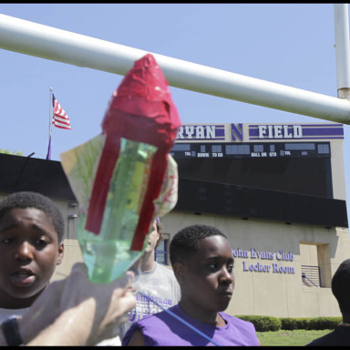 bottle rocket with 2 students watching it