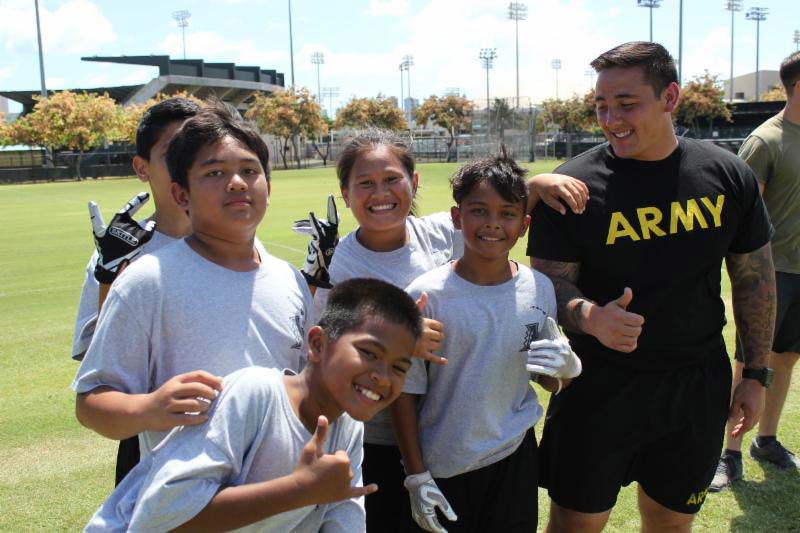 Small boys posing with an army man