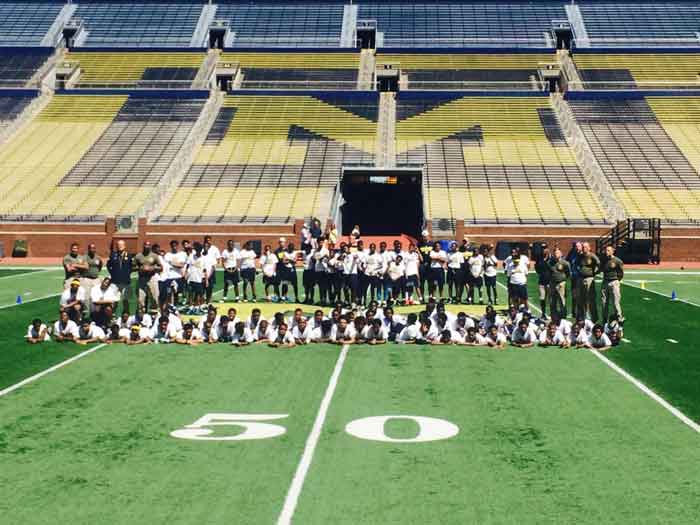 Group of students posing for photo on football field