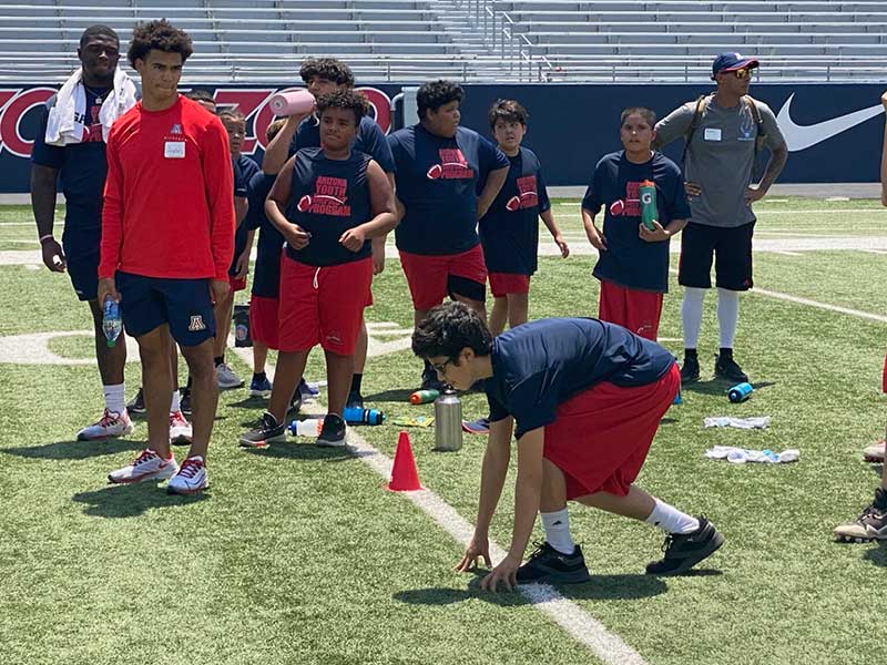 Student posing to start running on field