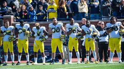 team standing with hand on chest