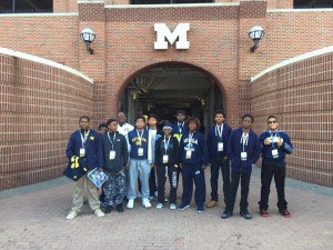 group of boys posing for photo at entrance with capital M on it