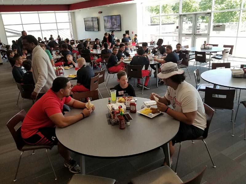 Boys and instructors sitting in the restaurant and eating