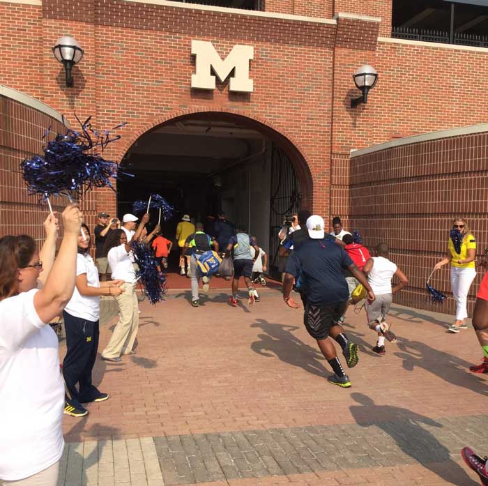 Students and players running in to the entrance of a building