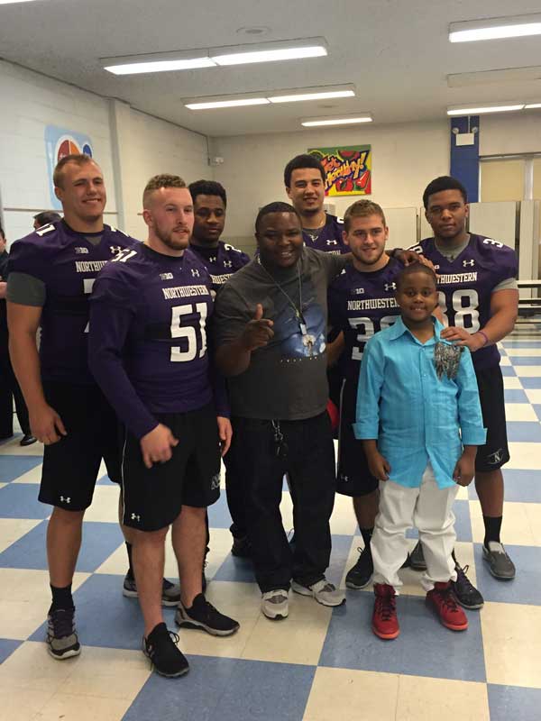 Students posing for photo with football players