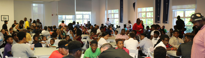 Students and adults sitting on a chair around a table