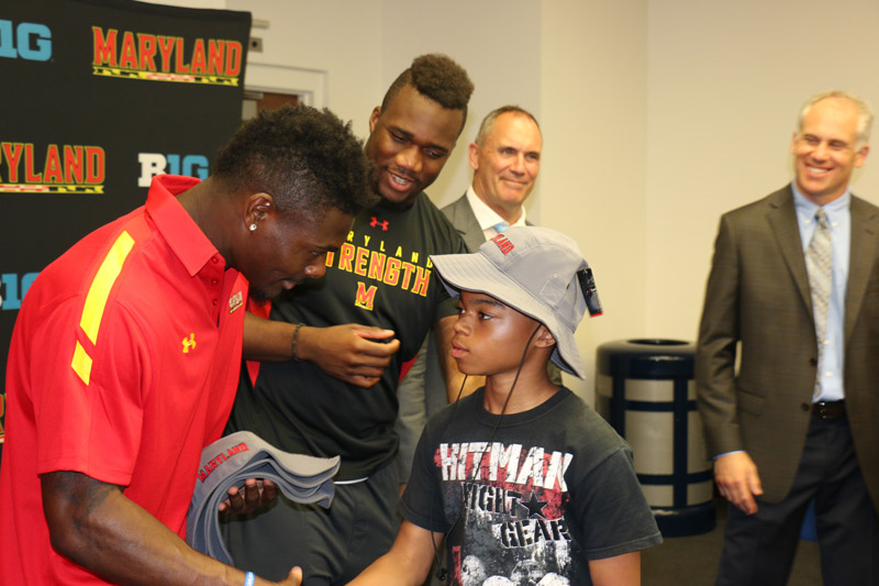 Football star shaking hands with student