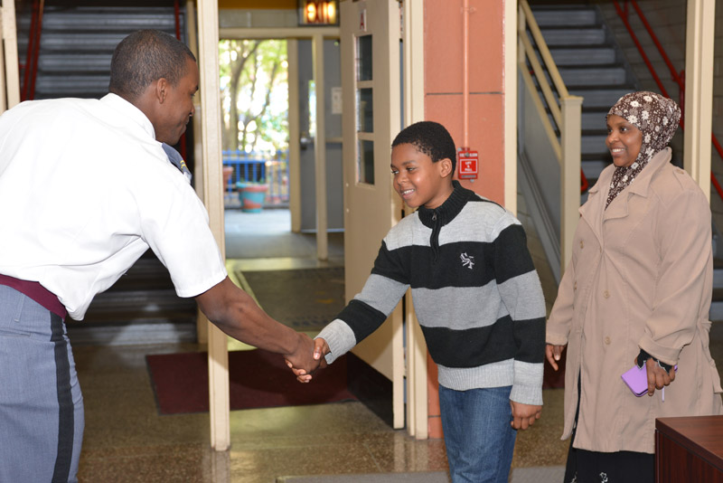 A man handshaking with a boy