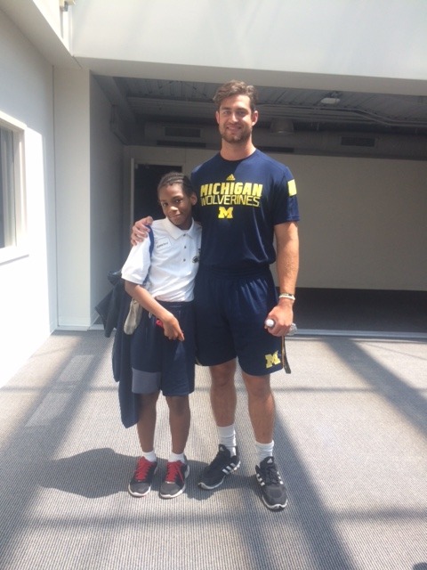 boy standing with coach michigan wolverines