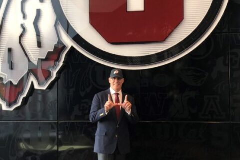 Utah Riki Pic in front of the logo wall