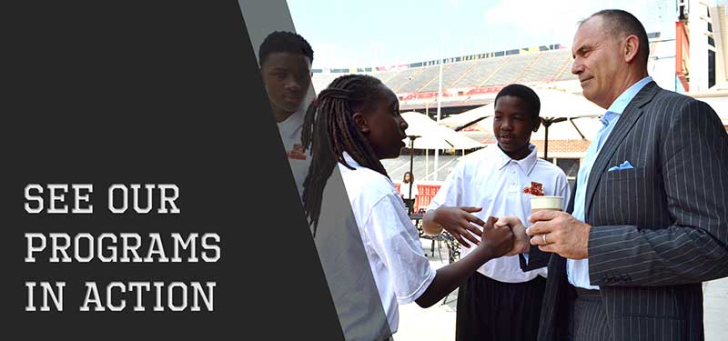 Man shaking hands with the small school children