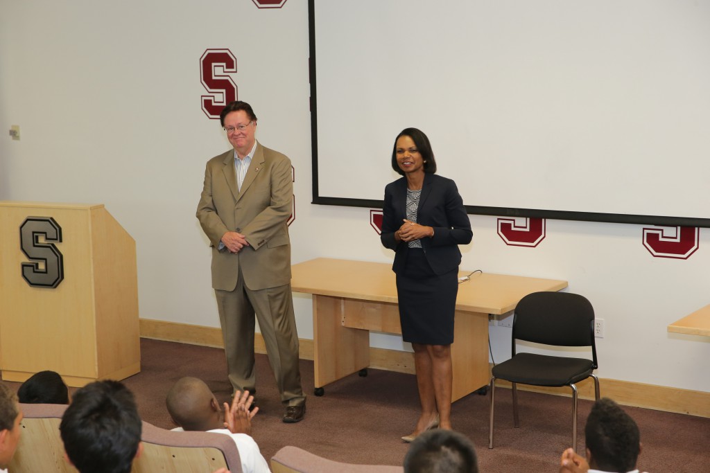 one women giving speech and one man standing beside