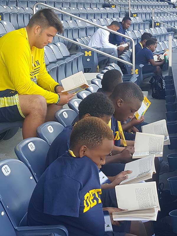 Boys reading books in the stadium