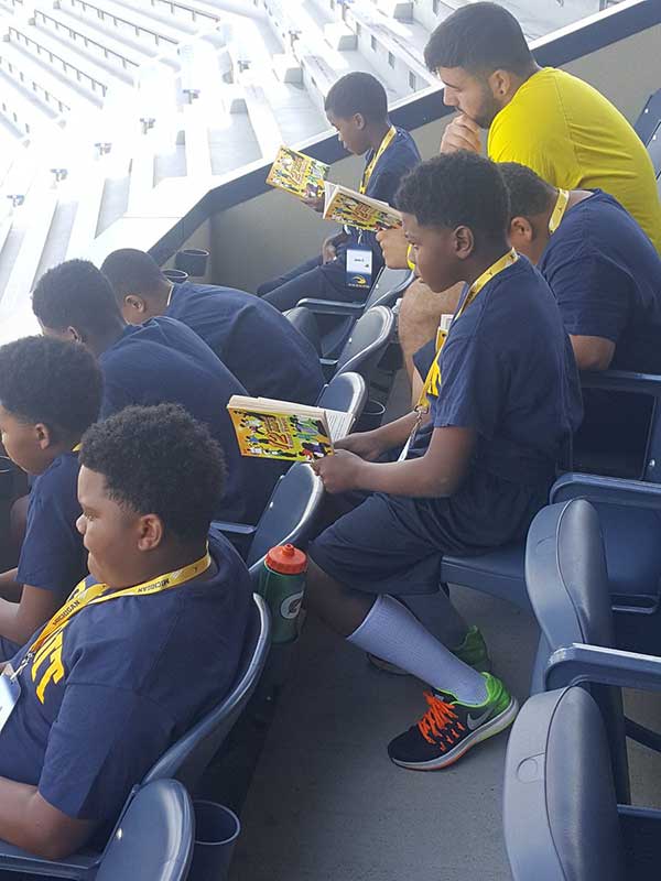 Boys reading books in the stadium