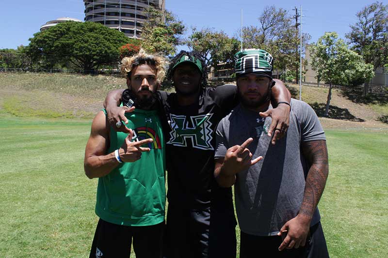 3 men standing for a photograph on the ground