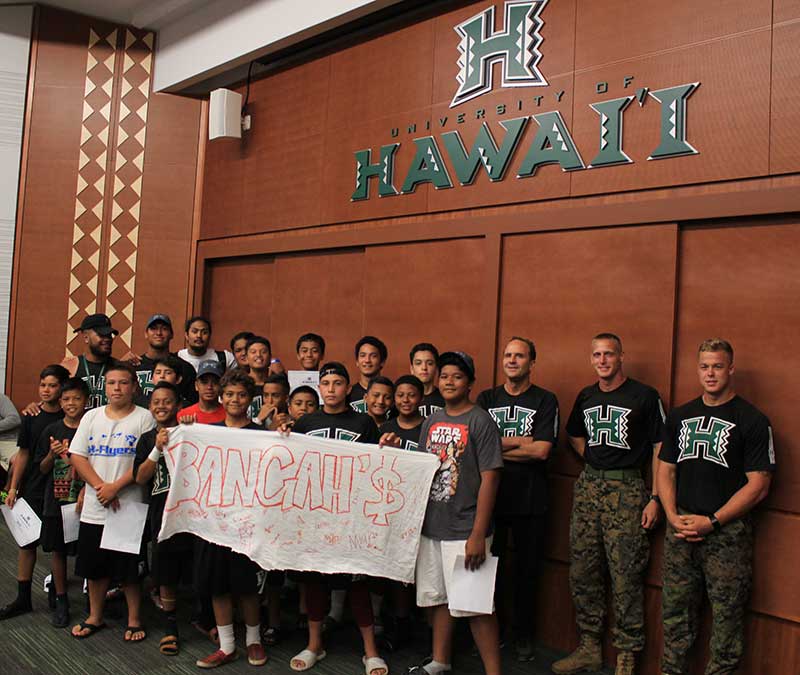 Group of boys with their instructor holding a banner and standing for the photograph