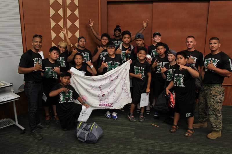 Group of boys with their instructor holding a banner and standing for the photograph